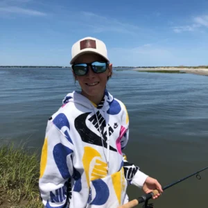 Fishing enthusiast in sunglasses by water